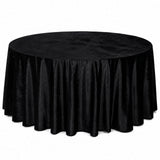 Round table covered with black velvet tablecloth on white background
