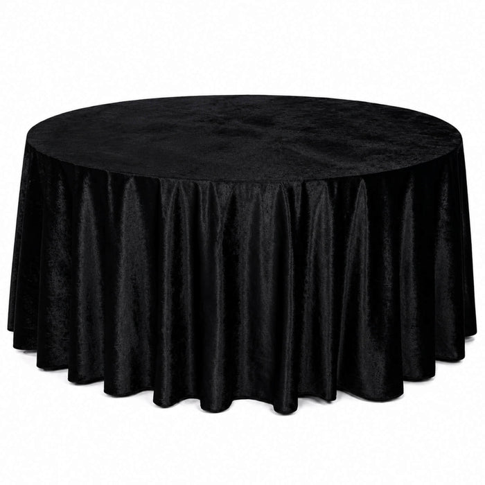 Round table covered with black velvet tablecloth on white background