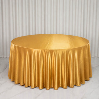 Gold round table with satin tablecloth in elegant event setting