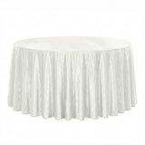Round white table with elegant draped tablecloth on a white background