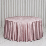 Round blush pink velvet tablecloth on a banquet table with white drapes
