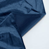 Close-up of navy blue velvet fabric with soft texture and folded edge