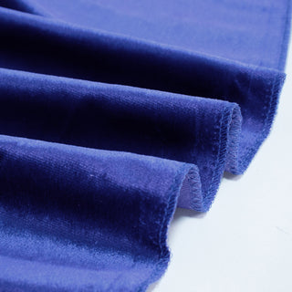 Close-up of folded royal blue velvet fabric with soft texture and stitched edges