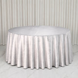 Round table with silver satin tablecloth on elegant neutral backdrop