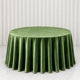 Round green velvet tablecloth on a banquet table with draped white backdrop