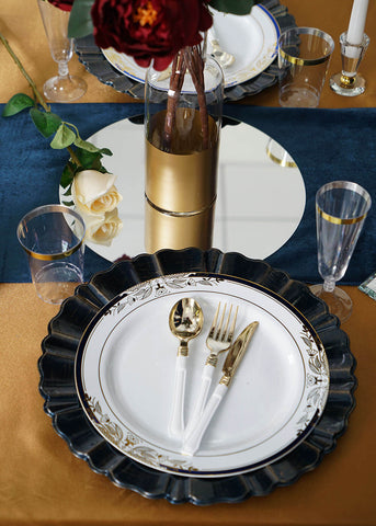 Close-up of navy charger plate with white dinnerware and gold cutlery