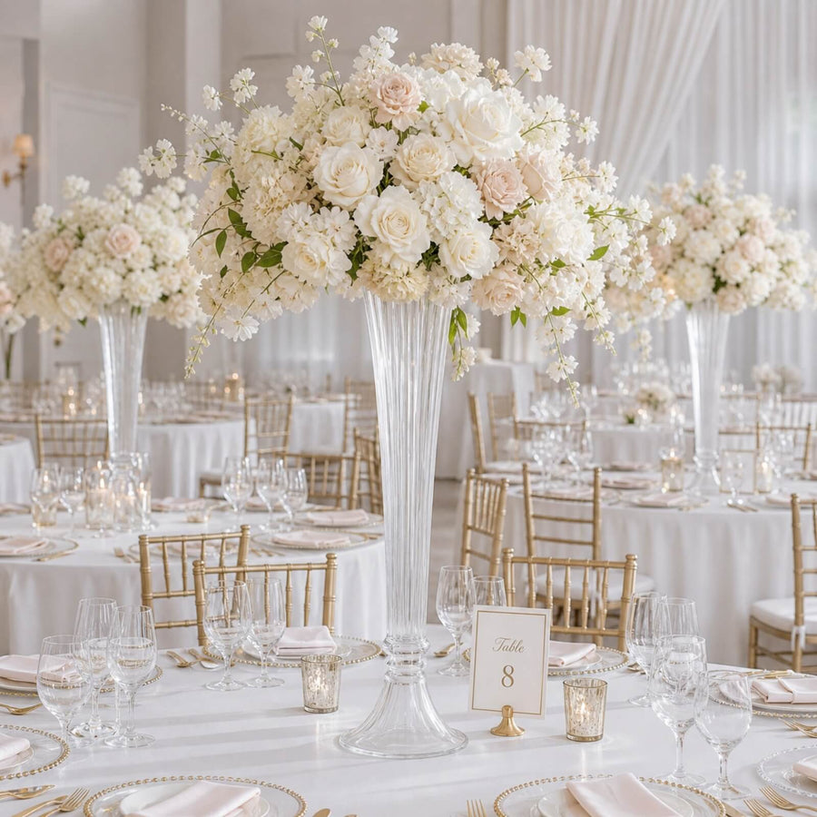 Elegant white and blush wedding reception table with tall floral centerpieces