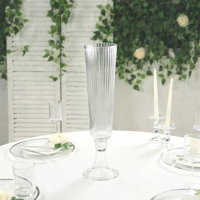 Elegant glass vase on a table set with candles and flowers.