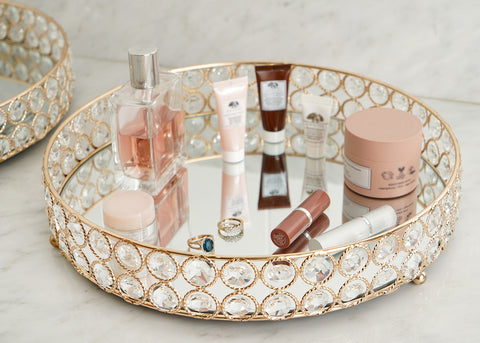 Round mirrored vanity tray with cosmetics
