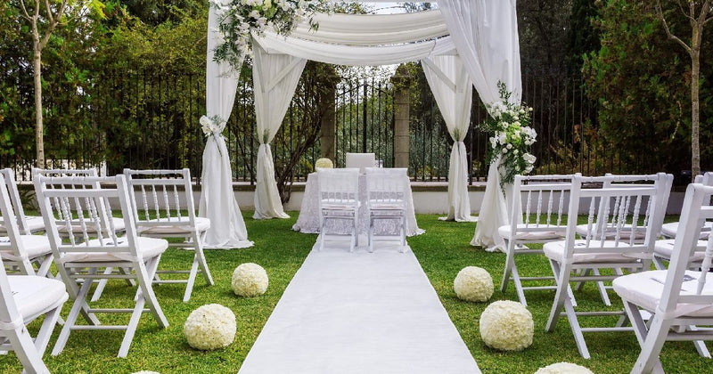 White draped wedding chuppah with aisle runner