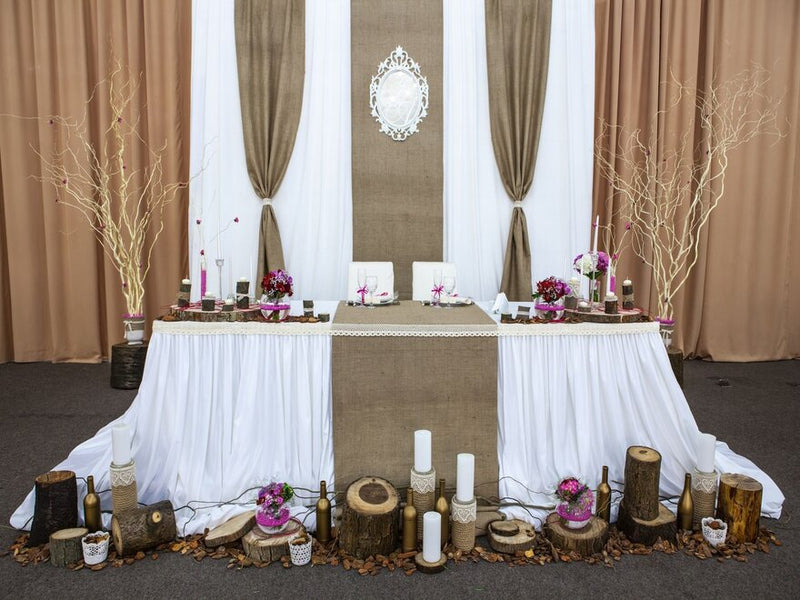 Rustic table setting with red candles and floral backdrop