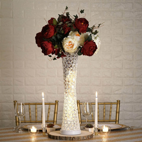 Heart-shaped ornament beside rose petals in glass dome