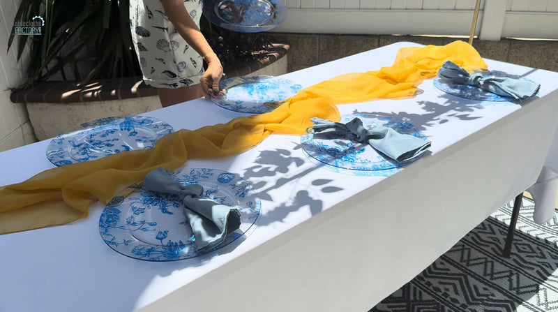 Amalfi Coast summer table setup with blue plates and soft yellow napkins.