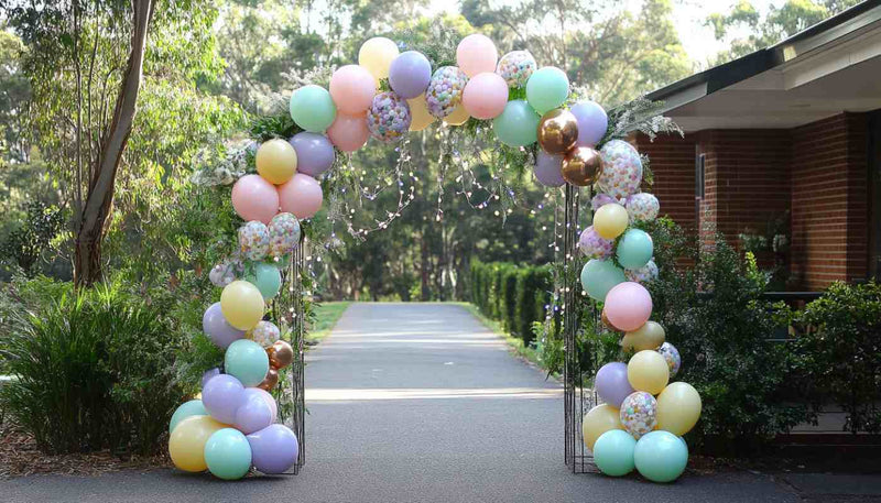 Pastel balloon arch framing an outdoor walkway