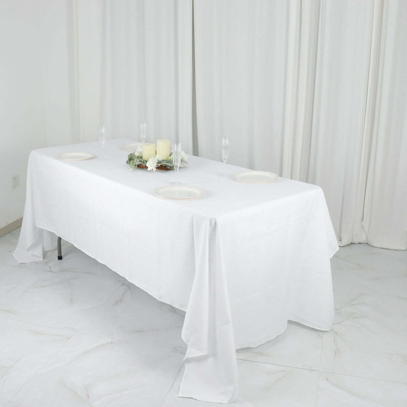 White tablecloth with floral centerpiece and glassware