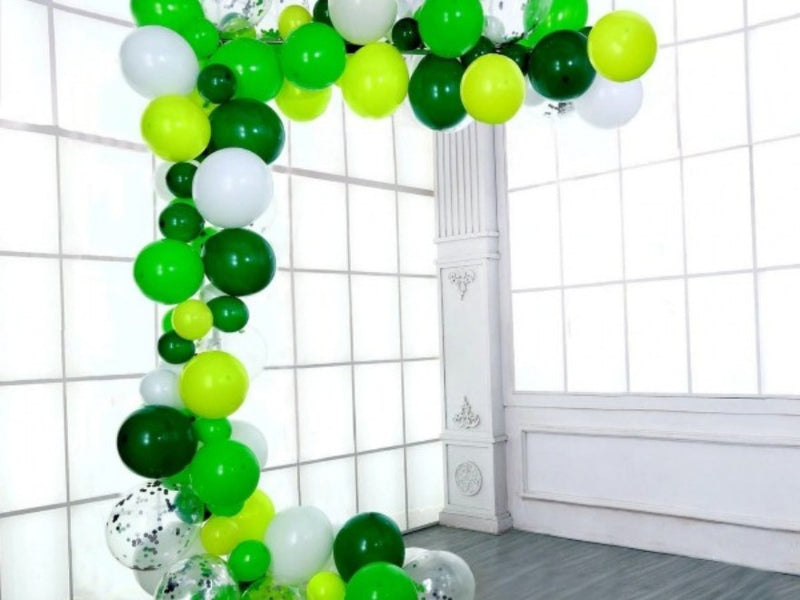 Green and white balloon garland in a white room
