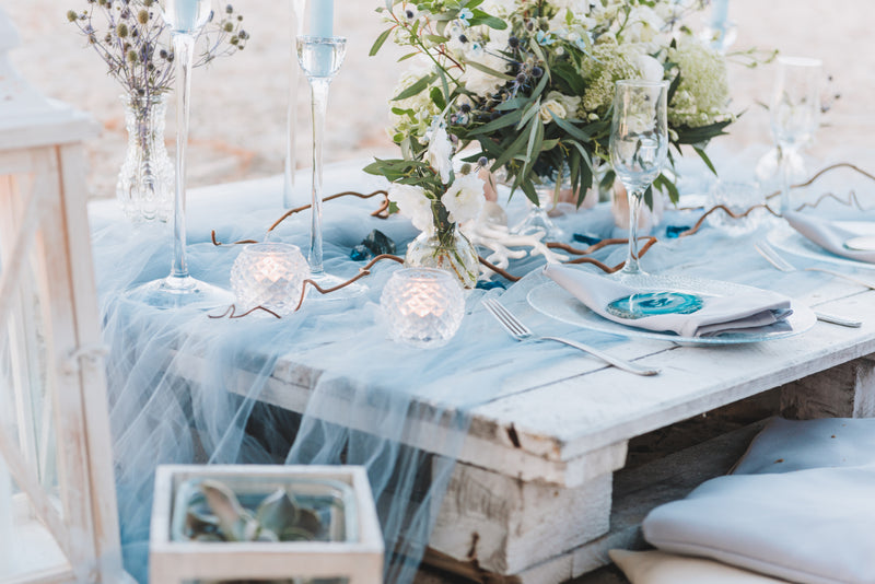 Blue wedding table setting with floral centerpiece