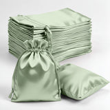 Set of satin drawstring bags in soft green color on a white background.