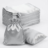 Stack of silver satin bags with one bag in the foreground.