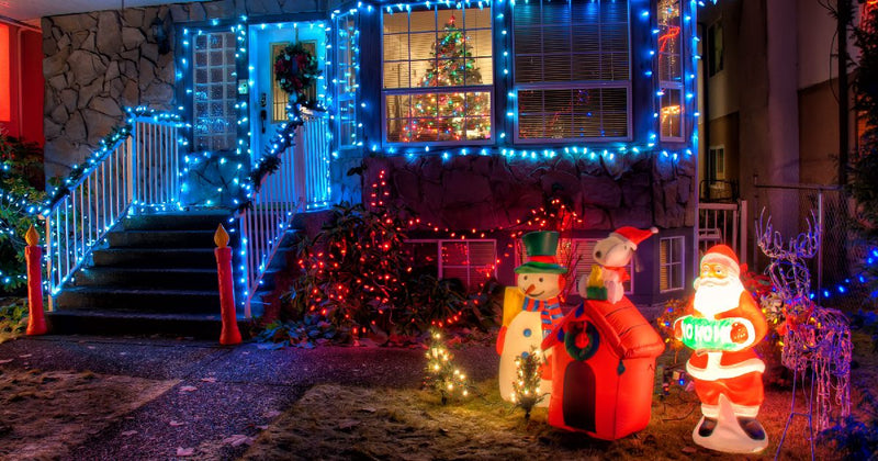 House decorated with blue Christmas lights and inflatable figures