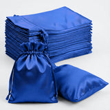 Stack of blue satin bags with a drawstring pouch on a plain background.