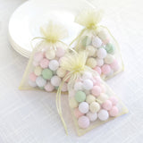 Pastel candy-filled gift bags tied with yellow ribbons.