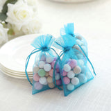 Colorful wooden balls in sheer blue gift bags on a table.
