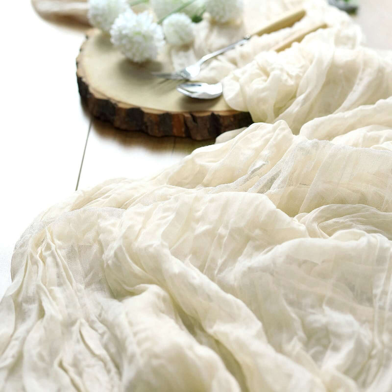Cream cheesecloth table runner draped over table