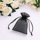 Black sheer organza drawstring pouch with floral backdrop