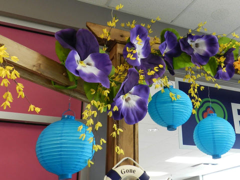 Purple flowers and blue lanterns on a wooden beam