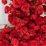 Vibrant red artificial flowers arrangement in a wooden box.