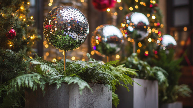 Disco ball ornament in a planter with greenery and lights
