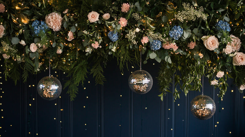 Three disco balls hanging beneath a floral arrangement