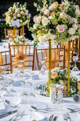 Gold flower stand with blush and cream floral arrangement