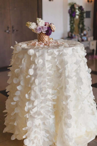 White petal-covered table with floral centerpiece