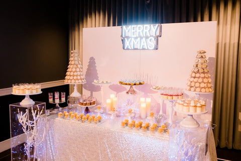 Dessert table with acrylic display boxes and a neon sign
