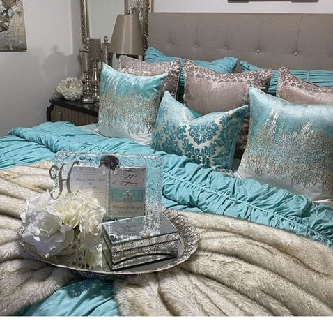 Crystal tray with white flowers and yellow candles on a bed