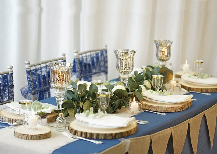 Blue table setting with candles and greenery