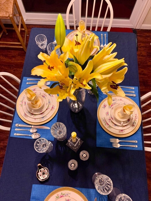 Table centerpiece with yellow flowers and blue placemats