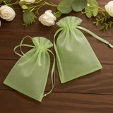 Green organza gift bags on a wooden surface.