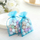 Colorful decorative balls in sheer blue bags for crafts or party favors.