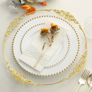 Elegant gold-rimmed plate with floral napkin and dried flowers on a table setting.