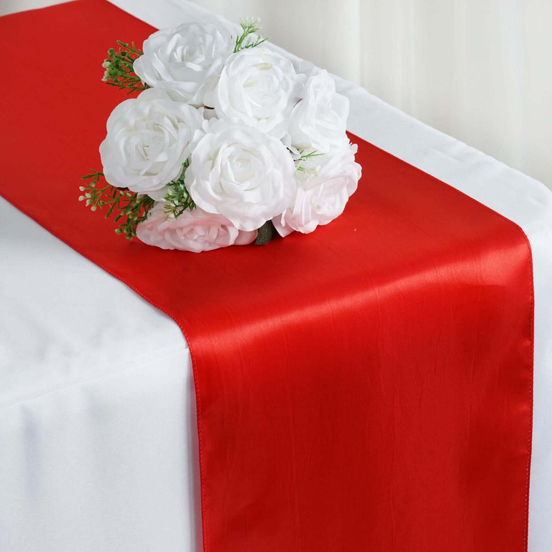 Red satin table runner with white flowers
