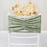 Green velvet chair cover with ruched design, styled against floral backdrop.