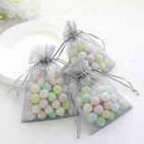 Pastel candy-filled organza bags on a table.