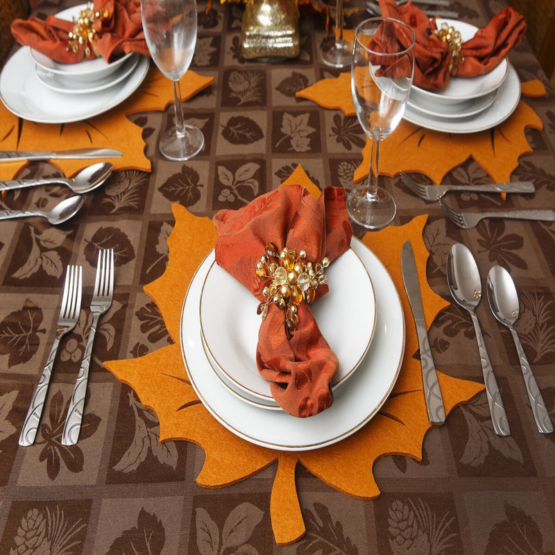 Fall table setting with orange napkin and leaf placemat