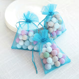 Colorful pastel candy-filled bags tied with blue ribbons.