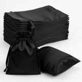 Set of black satin drawstring bags stacked and one bag open.