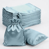 Set of blue satin bags and pillowcases stacked neatly.
