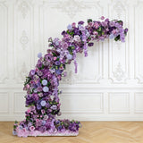 Floral arch display featuring purple and lavender blooms against a wall